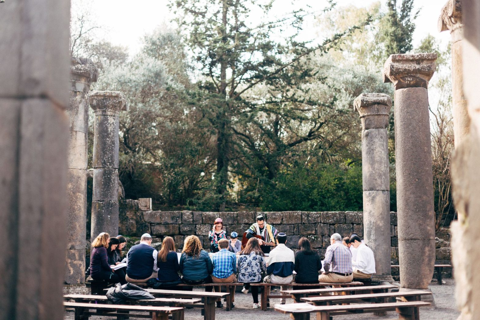 Group praying among ancient stone columns