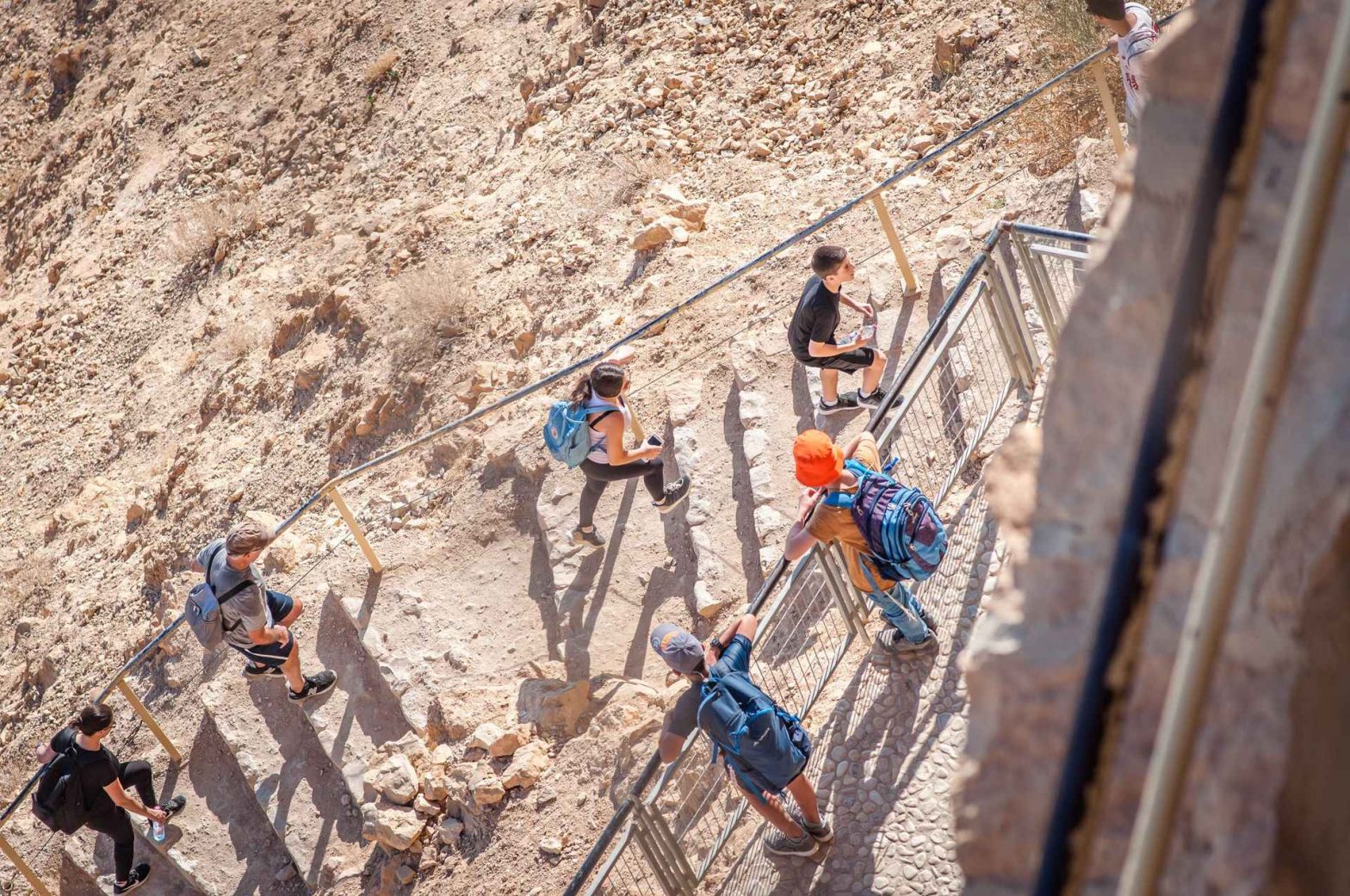 Hikers climbing rocky cliffside steps