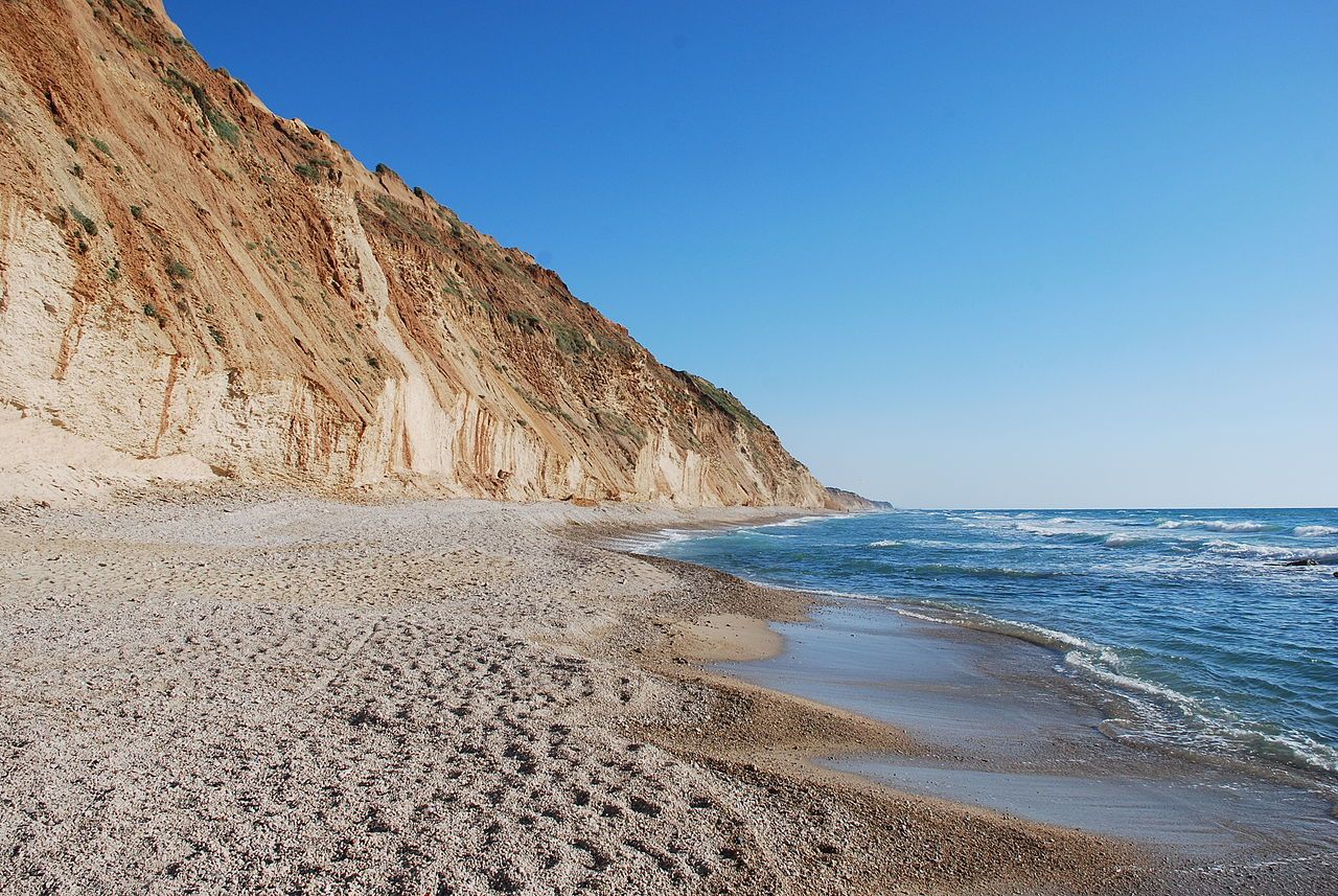 Cliff overlooking pebbled beach and waves
